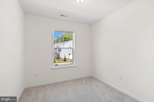 carpeted spare room featuring baseboards and visible vents