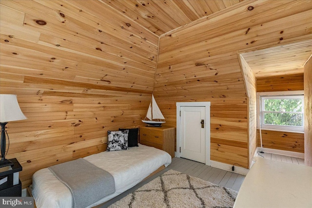 bedroom featuring wooden ceiling, wood walls, and wood finished floors