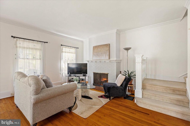 living room featuring ornamental molding, a brick fireplace, and wood finished floors