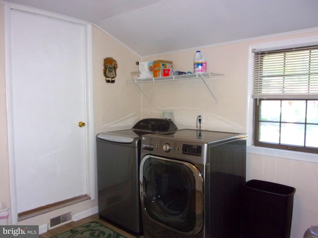 laundry room with laundry area, washing machine and dryer, and visible vents