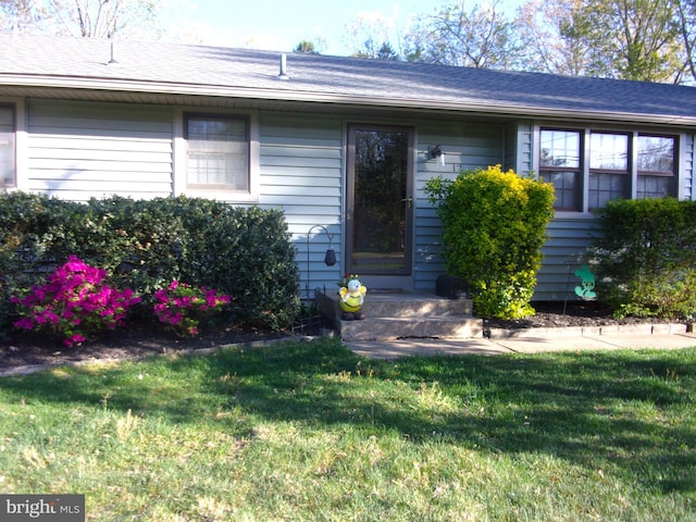 view of exterior entry with a lawn
