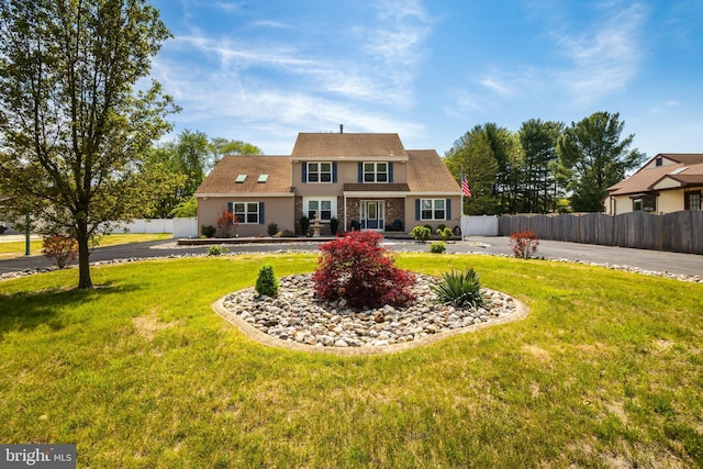 rear view of house with a lawn and fence