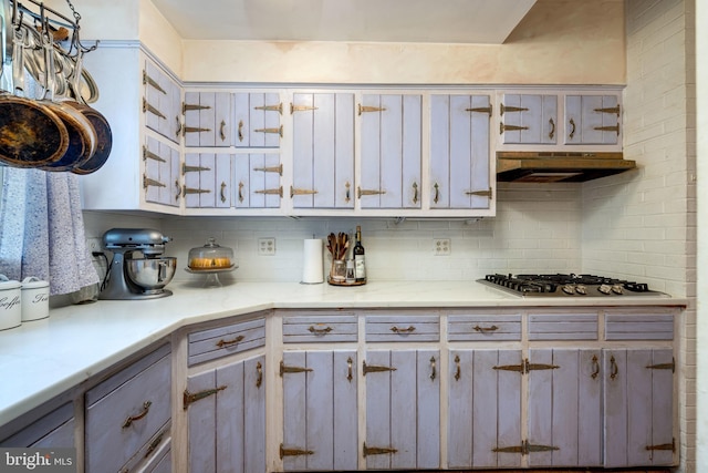 3909 Stoney Creek Rd, Edinburg, VA 22824 - kitchen featuring stainless steel gas cooktop, under cabinet range hood, light countertops, tasteful backsplash, and gray cabinetry