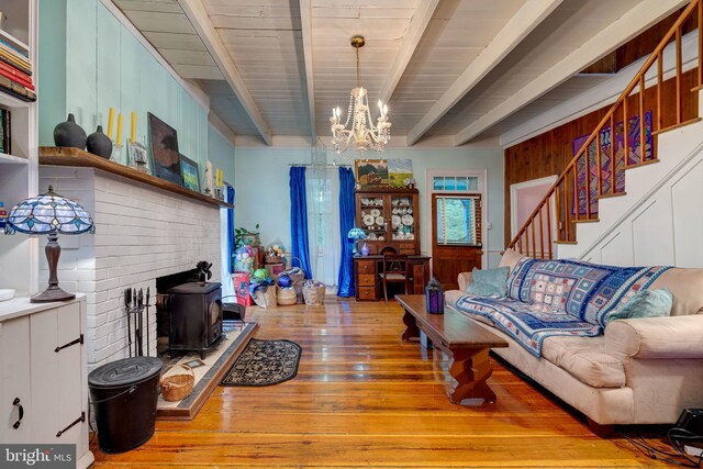 3909 Stoney Creek Rd, Edinburg, VA 22824 - living area featuring beam ceiling, a chandelier, hardwood / wood-style flooring, a wood stove, and stairway
