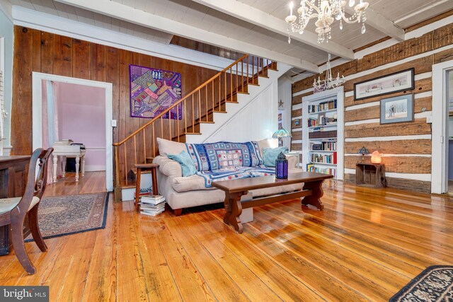 3909 Stoney Creek Rd, Edinburg, VA 22824 - living area with wooden walls, stairway, wood-type flooring, beamed ceiling, and a chandelier
