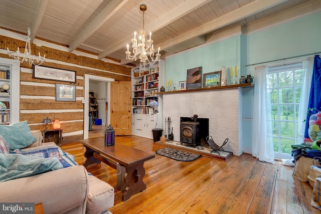 3909 Stoney Creek Rd, Edinburg, VA 22824 - living area with a chandelier, hardwood / wood-style floors, beamed ceiling, a wood stove, and wooden walls