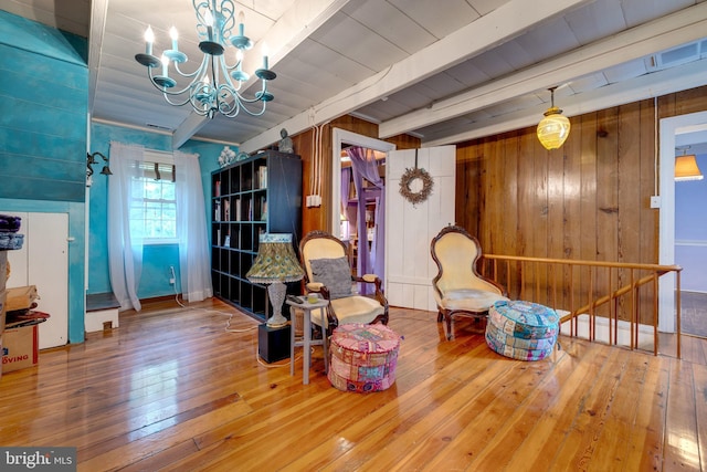 3909 Stoney Creek Rd, Edinburg, VA 22824 - sitting room featuring a chandelier, wood-type flooring, beam ceiling, wooden walls, and an upstairs landing
