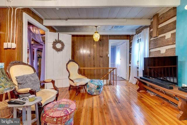 3909 Stoney Creek Rd, Edinburg, VA 22824 - sitting room with beam ceiling, wood-type flooring, wood walls, wood ceiling, and an upstairs landing