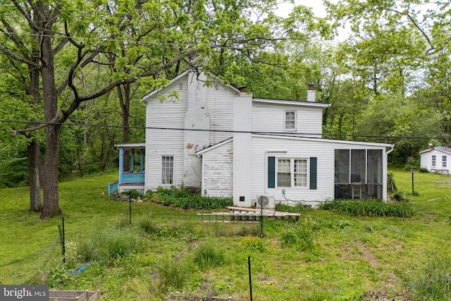 3909 Stoney Creek Rd, Edinburg, VA 22824 - back of house featuring a sunroom, a chimney, and a lawn