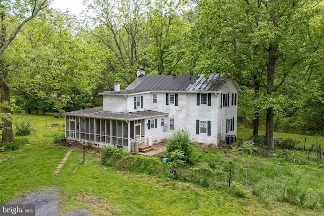 3909 Stoney Creek Rd, Edinburg, VA 22824 - back of house with a sunroom, a chimney, a lawn, and a wooded view