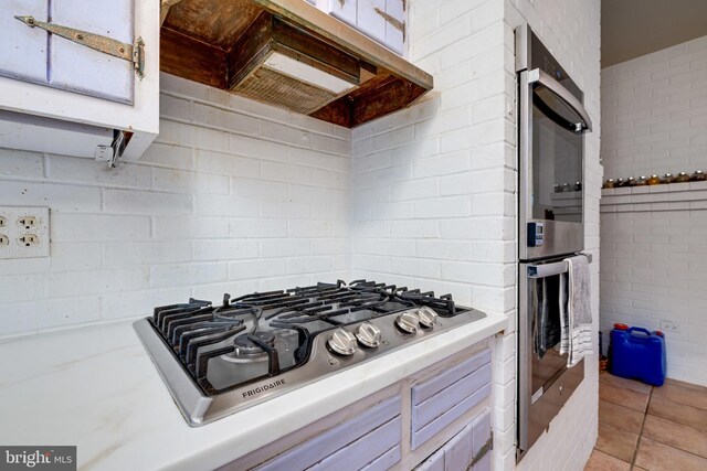 3909 Stoney Creek Rd, Edinburg, VA 22824 - kitchen featuring stainless steel appliances, light countertops, under cabinet range hood, and light tile patterned floors