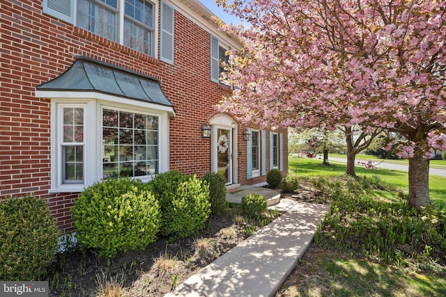 doorway to property with brick siding