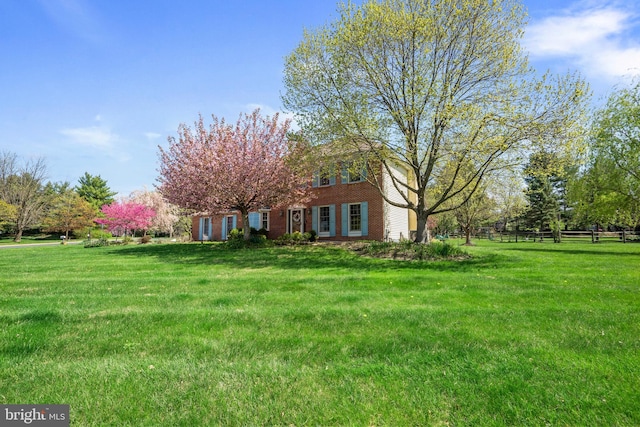 view of front facade featuring fence and a front lawn