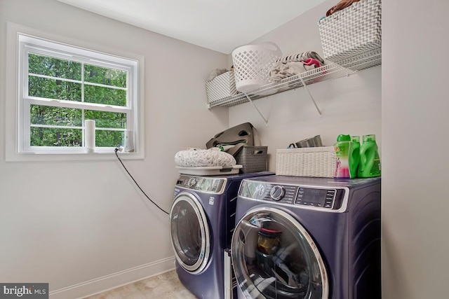 washroom with washing machine and clothes dryer and baseboards