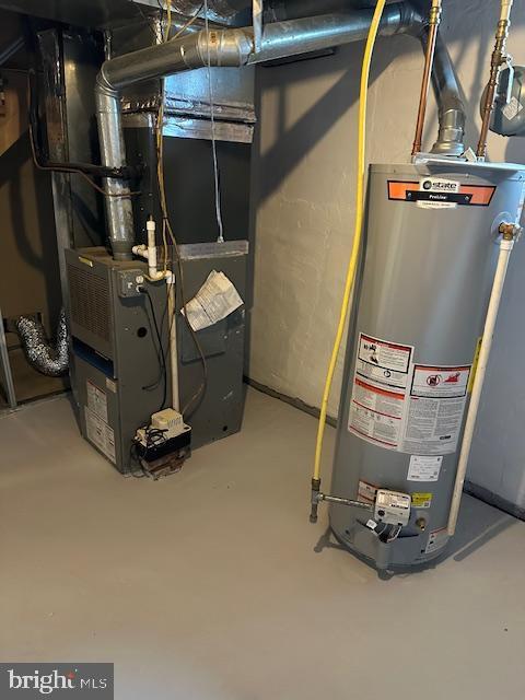 utility room featuring heating unit and gas water heater