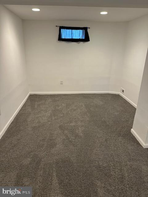 empty room with recessed lighting, baseboards, and dark colored carpet