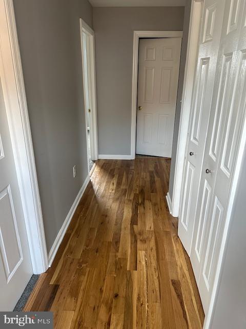 hallway with baseboards and wood finished floors