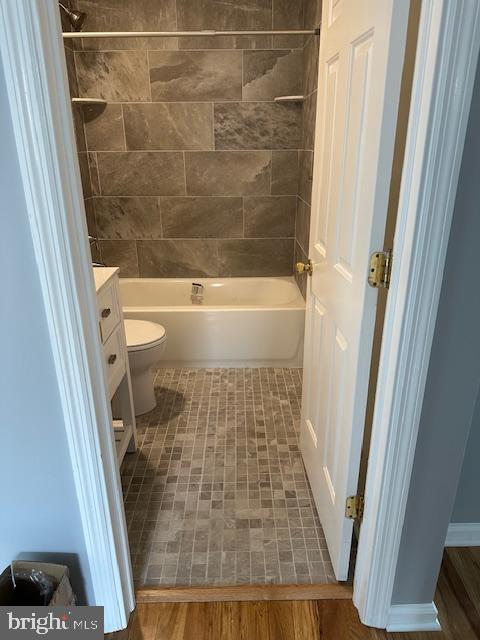 bathroom with vanity, toilet, and  shower combination