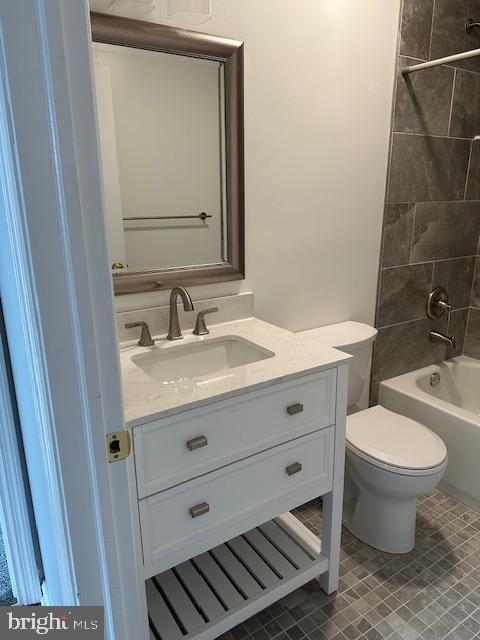 bathroom with vanity, toilet, and shower / tub combination