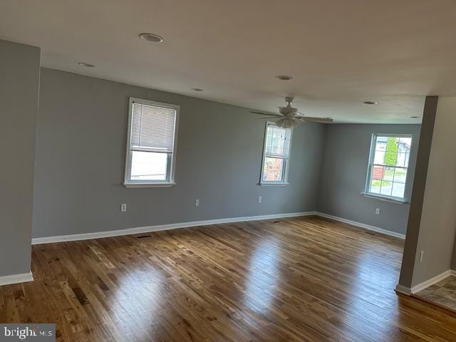 unfurnished room featuring baseboards, ceiling fan, and wood finished floors