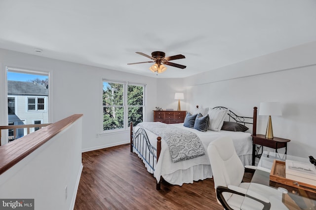 bedroom featuring baseboards, dark wood finished floors, and multiple windows