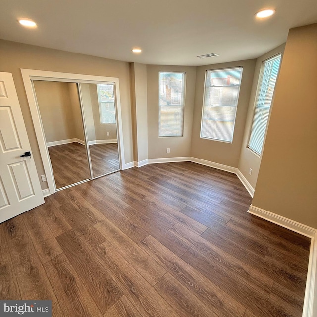 unfurnished bedroom featuring recessed lighting, baseboards, dark wood finished floors, and visible vents
