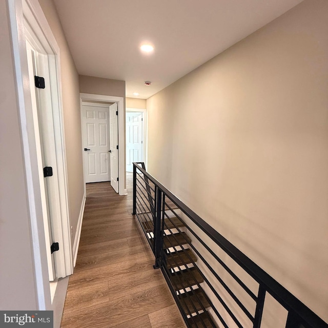 hall featuring recessed lighting, baseboards, an upstairs landing, and wood finished floors