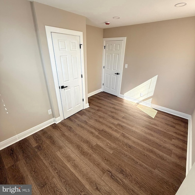 empty room with baseboards and wood finished floors