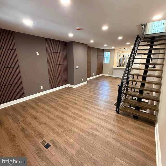 basement with visible vents, stairs, wood finished floors, baseboards, and recessed lighting