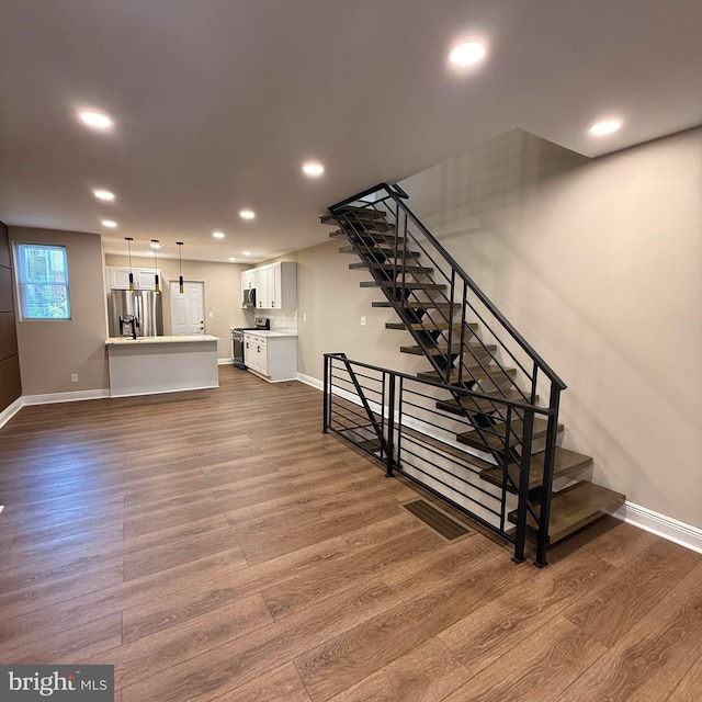 interior space featuring stairs, recessed lighting, baseboards, dark wood-type flooring, and visible vents