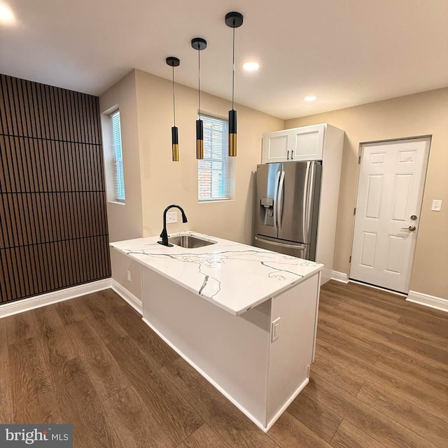 kitchen with a sink, stainless steel fridge with ice dispenser, baseboards, a peninsula, and dark wood-type flooring