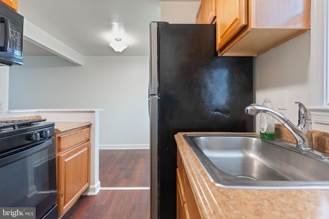 2512 Kent Village Dr, Landover, MD 20785 - kitchen with black appliances, a sink, light countertops, dark wood finished floors, and baseboards