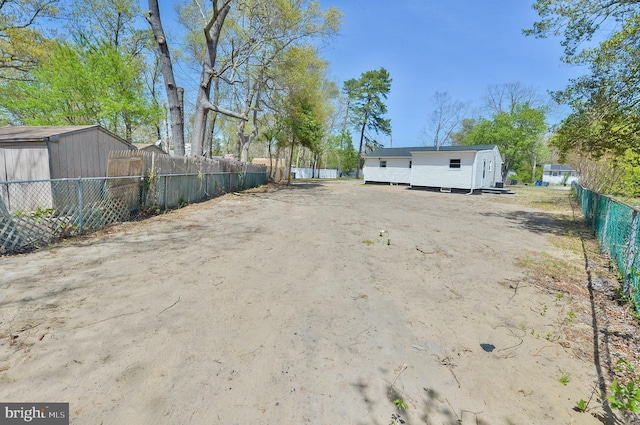 view of yard with fence and an outdoor structure