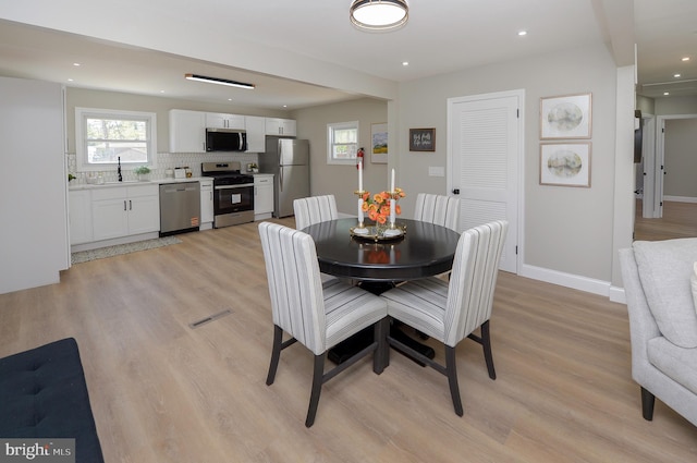 dining area with plenty of natural light and light wood-style floors