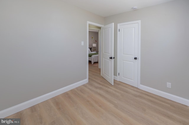 unfurnished bedroom with light wood-style floors and baseboards