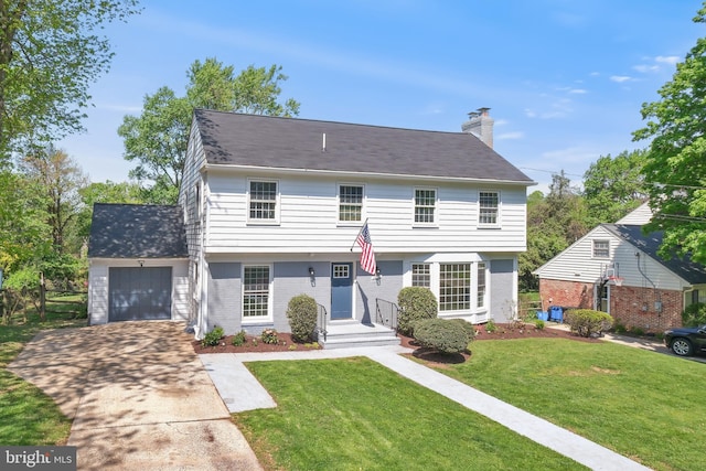 view of front facade with a chimney, a front yard, a garage, brick siding, and concrete driveway