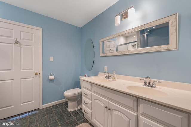 full bathroom with toilet, baseboards, double vanity, and tile patterned floors