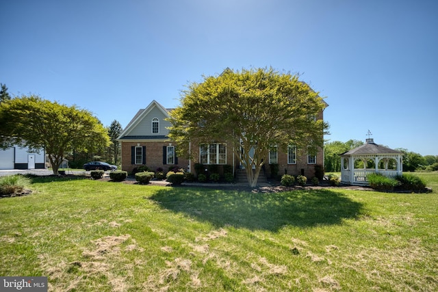 view of front of property with a gazebo, a front lawn, and brick siding