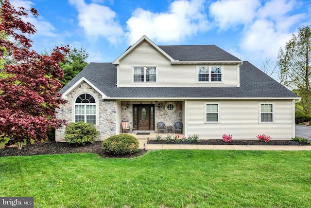 traditional home with a shingled roof, a front lawn, covered porch, and stone siding