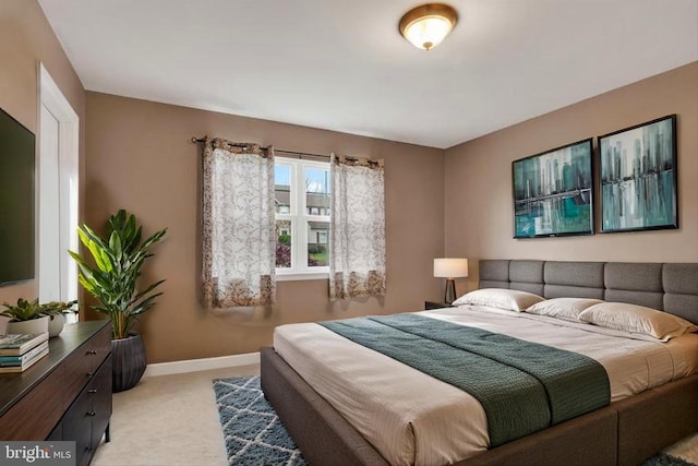 bedroom featuring baseboards and light carpet