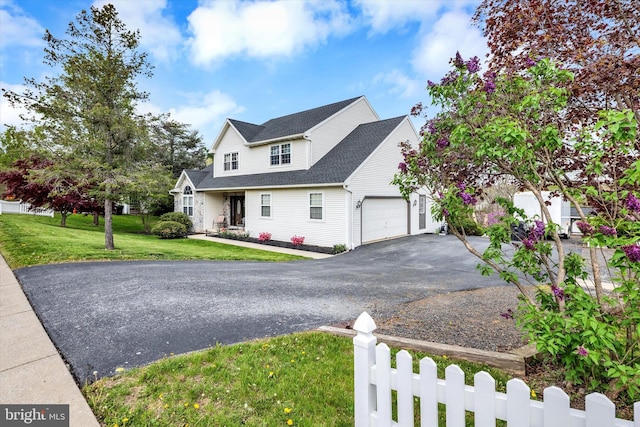 view of front of property with an attached garage, fence, a front lawn, and aphalt driveway