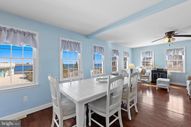 dining room with baseboards, ceiling fan, wood finished floors, and beam ceiling