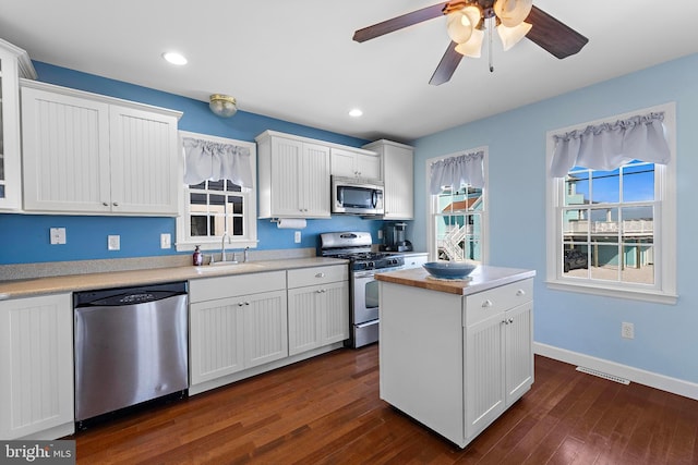 kitchen featuring visible vents, ceiling fan, white cabinets, a sink, and stainless steel appliances