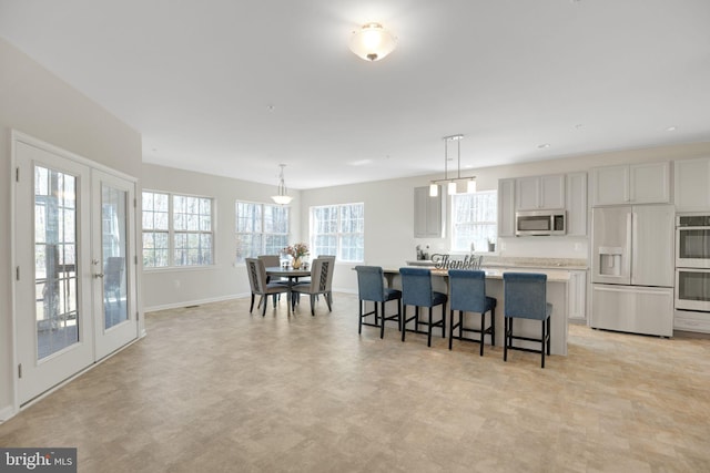 7438 Wildseed Pl, Hughesville, MD 20637 - kitchen with french doors, a kitchen breakfast bar, a healthy amount of sunlight, and stainless steel appliances