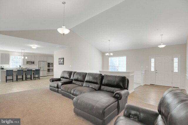 7438 Wildseed Pl, Hughesville, MD 20637 - living area with an inviting chandelier, lofted ceiling, a wealth of natural light, and a wainscoted wall