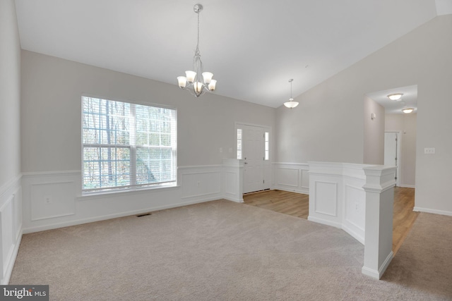 7438 Wildseed Pl, Hughesville, MD 20637 - spare room featuring an inviting chandelier, light carpet, lofted ceiling, and a wainscoted wall