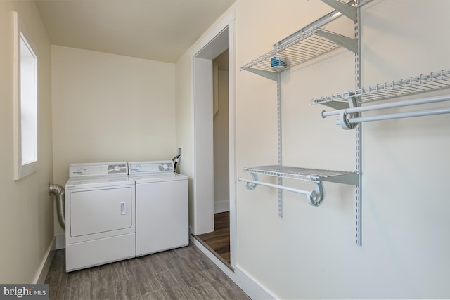 washroom with laundry area, baseboards, washing machine and dryer, and wood finished floors