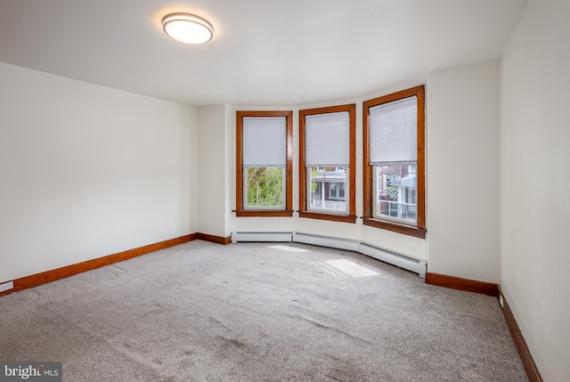 carpeted empty room featuring baseboards