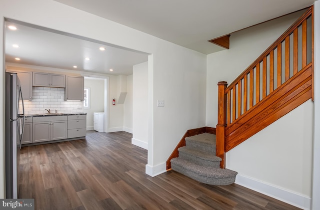 interior space with decorative backsplash, dark wood finished floors, gray cabinetry, freestanding refrigerator, and recessed lighting