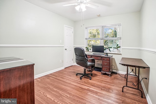 office space featuring baseboards, a ceiling fan, and wood finished floors